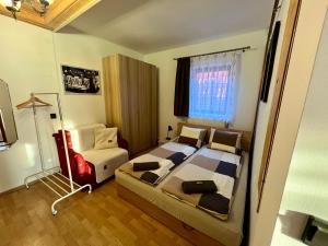 a bedroom with two beds and a chair in it at Becehegyi Vendégház in Balatongyörök