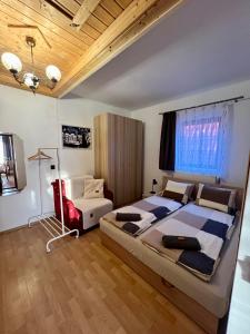 a bedroom with a large bed and a red chair at Becehegyi Vendégház in Balatongyörök
