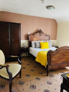 um quarto com uma cama com um cobertor amarelo em Crown Hotel Brackley em Brackley