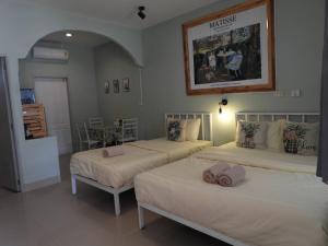 a bedroom with two beds and a table at 888 private room near khaoyai in Mu Si