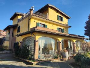 a large yellow house with a large window at B&B Camera delle Camelie in Palestrina