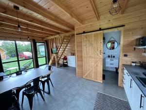 a kitchen and dining room of a log cabin at Stodoły na Mierzei in Kąty Rybackie