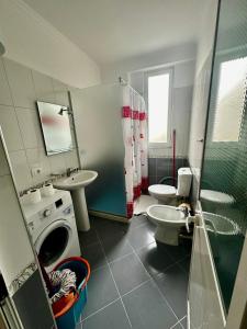 a bathroom with a toilet sink and a washing machine at Villa Arberia in Durrës