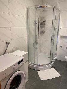 a bathroom with a shower and a washing machine at Villa Jasmin in Bol