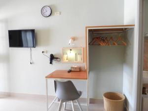 a desk in a room with a chair and a clock at 888 private room near khaoyai in Mu Si