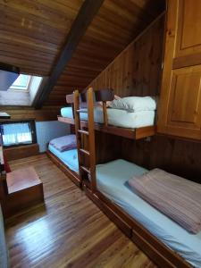 a room with three bunk beds in a cabin at Mansarda trilocale direttamente sulla pista a Folgarida - Belvedere in Folgarida