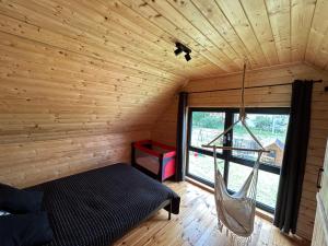 Zimmer mit einem Bett und einer Hängematte in einer Hütte in der Unterkunft Stodoły na Mierzei in Kąty Rybackie