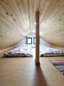 two beds in a room with a wooden ceiling at Tiny House Stefana with garden in Transylvania 