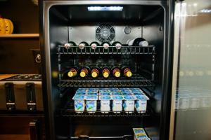 un refrigerador lleno de botellas de cerveza y leche en Forest Boutique, en Piteşti