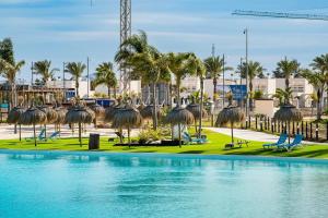 - une piscine avec des chaises et des palmiers dans un complexe dans l'établissement Sunrise Santa Rosalia Terrace, à Murcie