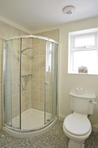La salle de bains est pourvue d'une douche, de toilettes et d'une fenêtre. dans l'établissement 26 Pier Avenue, à Southwold