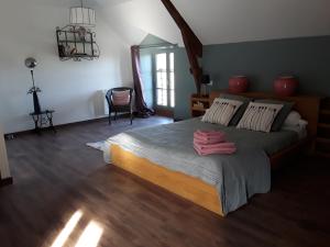 ein Schlafzimmer mit einem großen Bett mit zwei Handtüchern darauf in der Unterkunft La petite seigneurie de Lourmel in Carentoir