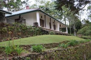 Casa blanca con pared de piedra y patio en Eastland Bungalow, Hewaheta, Kandy en Hewaheta