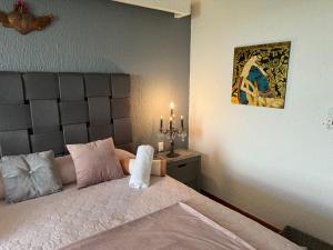 ein Schlafzimmer mit einem Bett mit einem Kopfteil und einer Kerze in der Unterkunft Spectacular Beach Romantic Sunset Lagoon View Studio in Cancún