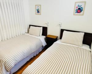 two beds sitting next to each other in a bedroom at Hostal Almares in Pichilemu