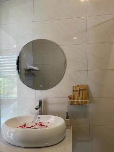 bagno con lavandino bianco e specchio di Son Home Garden a Hue