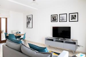 - un salon avec un canapé et une télévision dans l'établissement Ballatoio Apartment by the Lake, à Lesa