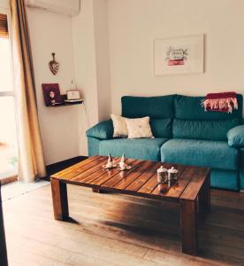 ein Wohnzimmer mit einem blauen Sofa und einem Couchtisch in der Unterkunft La Casa de la Luz, ático con terraza privada, Parking Free in Cartagena