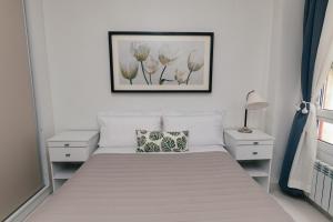 a bedroom with a bed with a picture on the wall at Departamentos Patagonia in Ushuaia