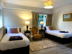 um quarto de hotel com duas camas e uma cadeira em Moortown House em Market Rasen