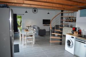 a kitchen and living room with a table and a washer at Joinville : Grange entièrement rénovée style loft. in Joinville