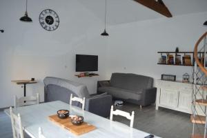 a living room with a table and a couch at Joinville : Grange entièrement rénovée style loft. in Joinville