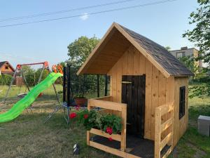 a wooden dog house with a green slide at Stodoły na Mierzei in Kąty Rybackie
