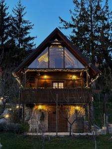 a log cabin with a large window and lights at Javor Holiday House in Žumberak
