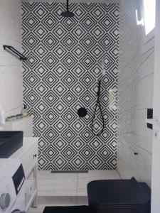 a bathroom with a black and white patterned wall at Feel like Home Villa in Schinias