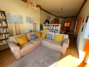 sala de estar con sofá y almohadas amarillas en Casa da Abrunheira 