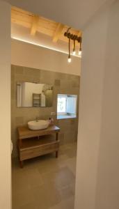 ein Bad mit einem Waschbecken und einem Spiegel in der Unterkunft Arcaroli Borgo Vico "Exclusive" in Vico del Gargano