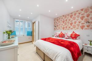 a bedroom with a large bed with red pillows at N° 28 The Salcombe in Salcombe