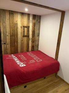 レ・キャローズ・ダラッシュにあるLes Carroz d'Arachesの赤毛布付きのドミトリールームのベッド1台分です。