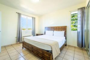 a bedroom with a large bed and two windows at West Coast Apartments in Boqueron +38 photos