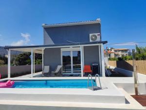 a house with a swimming pool in front of it at Feel like Home Pool Villa in Schinias