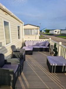 a patio with couches and chairs on a deck at 35 Irby way in Lincolnshire