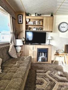 een woonkamer met een bank en een flatscreen-tv bij 35 Irby way in Lincolnshire