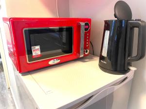 a red microwave sitting on top of a shelf at Apartments Pellinger-Hof in Pellingen +13 photos