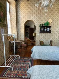 a living room with two beds and a table at B&B Chiara in San Sebastiano Curone