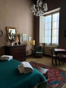 1 dormitorio con cama, espejo y mesa en B&B Chiara, en San Sebastiano Curone