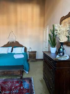 a bedroom with a bed and a dresser with a plant on it at B&B Chiara in San Sebastiano Curone