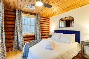 - une chambre avec un lit dans une pièce dotée de murs en bois dans l'établissement Secluded Naples Cabin with Deck and Stream Views, à Naples