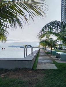 a row of benches next to a body of water at JQ ArasTwo Homestaykk LEVEL 22 SEAVIEW in Kota Kinabalu