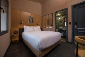a bedroom with a large white bed and a bathroom at Motto By Hilton Cusco in Cusco