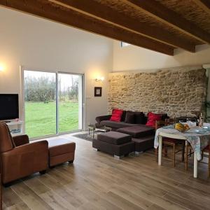 ein Wohnzimmer mit Sofa und Tisch in der Unterkunft Maison lumineuse entre mer et campagne 6 personnes in Plouguerneau