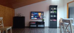 sala de estar con TV de pantalla plana en la pared en Masia La Roca, en Castellnou de Bages