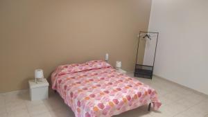 1 dormitorio con 1 cama con edredón rosa en Lino's house, en Adrano