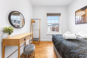 una camera con letto, scrivania e specchio di Modern One Bedroom Flat - Near Heathrow, Windsor Castle, Thorpe Park - Staines London TW18 a Londra