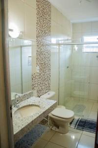 een badkamer met een toilet, een wastafel en een douche bij Rancho para Temporada,Três Marias mg. in Três Marias