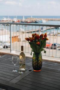 un jarrón de flores en una mesa con una botella y vasos en Zima Two Seaside, en Zygi